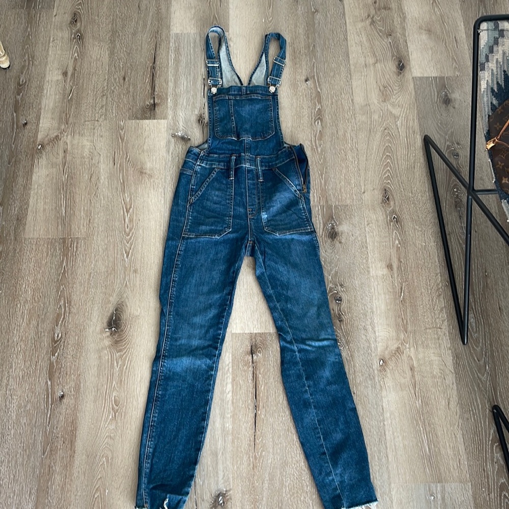 Denim overalls. Skinny leg with distressed hem.